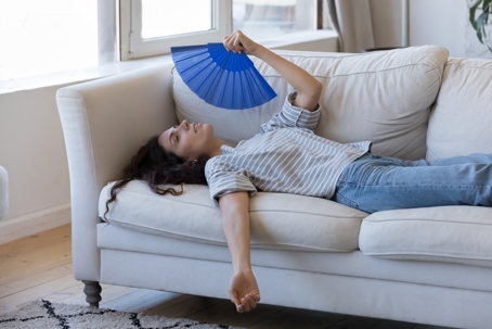 Woman fanning herself on the couch
